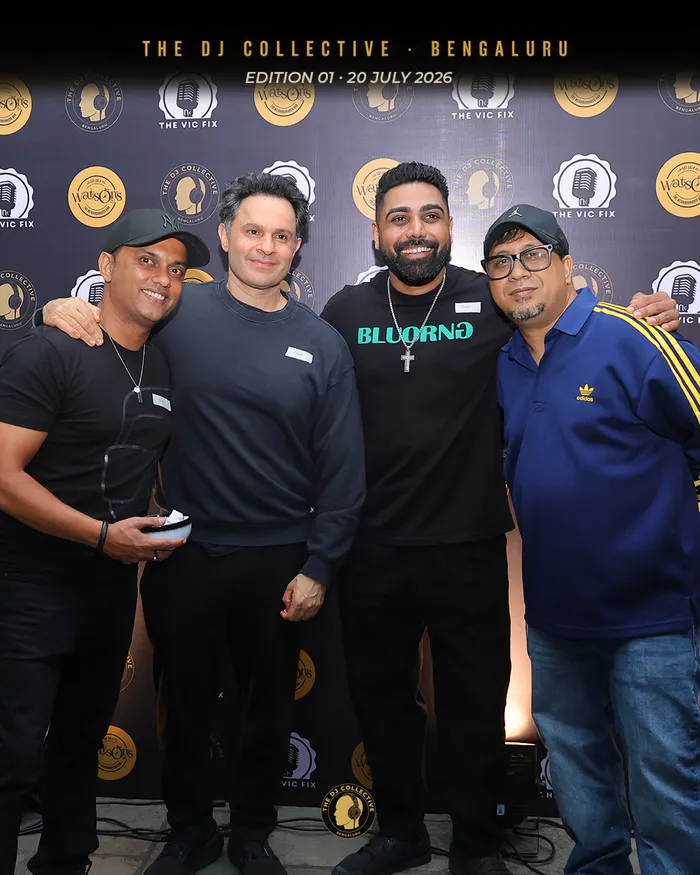 Four DJs posing, one with an arm around the next