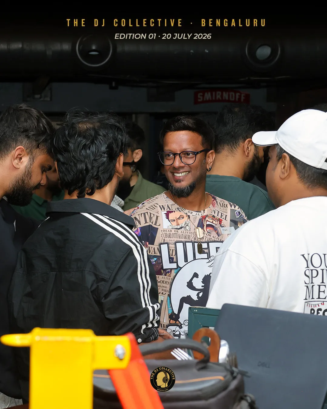 A DJ smiling in a packed crowd near the bar