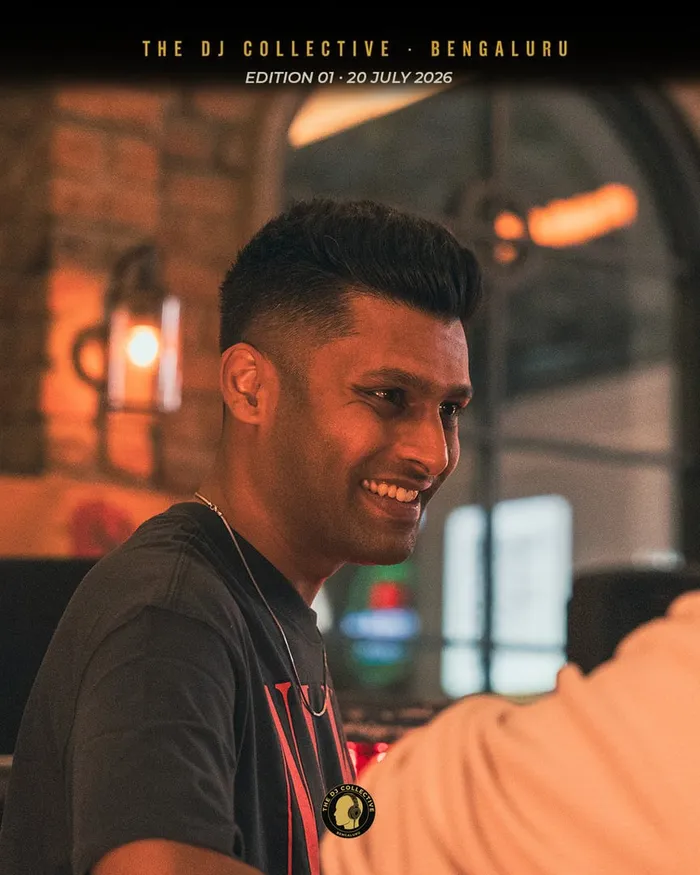 A DJ smiling in profile at a table