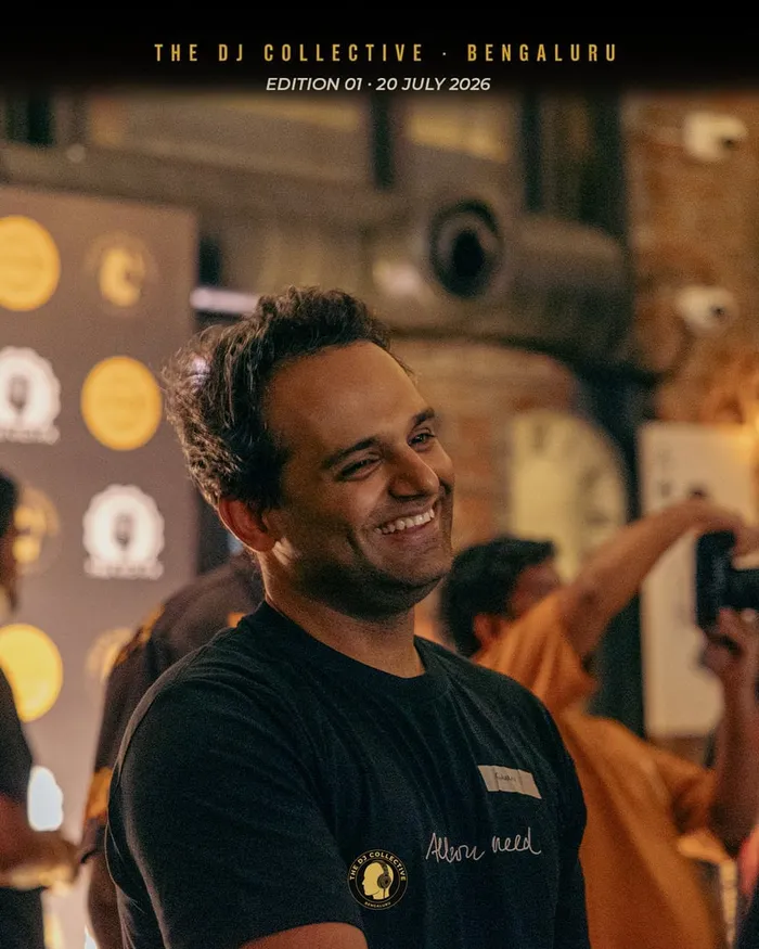 A DJ laughing while a photographer shoots nearby