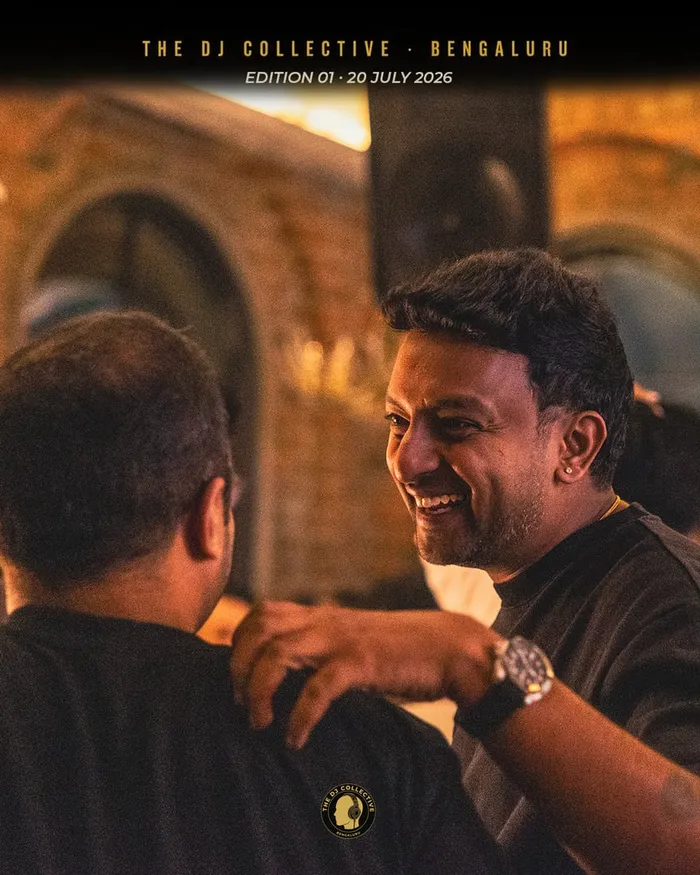 Two DJs talking closely, one laughing