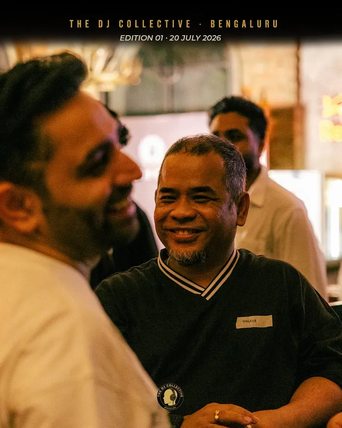 A group in conversation, two of them smiling at each other