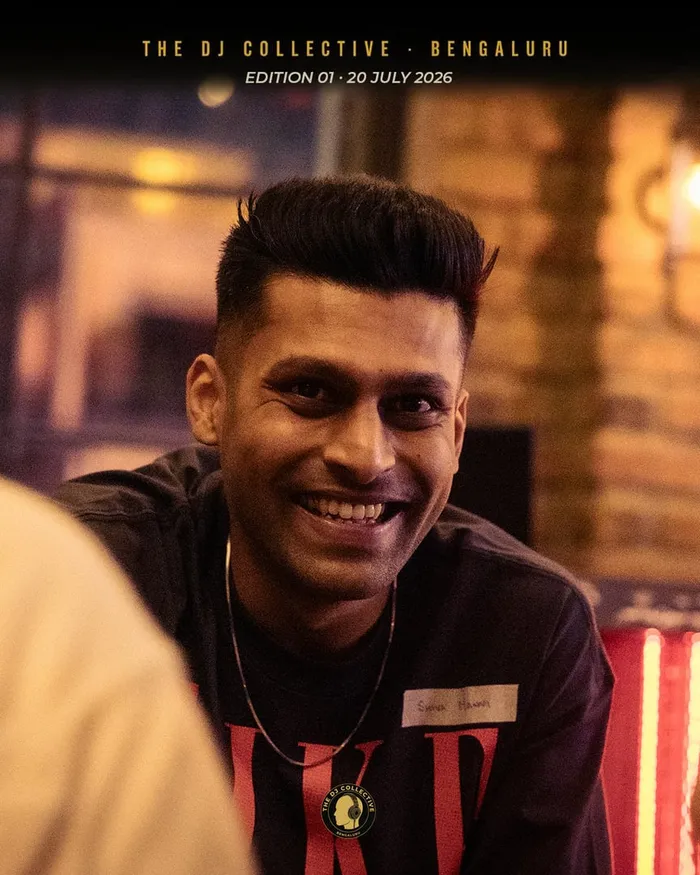 A DJ in a red-striped top smiling at a table