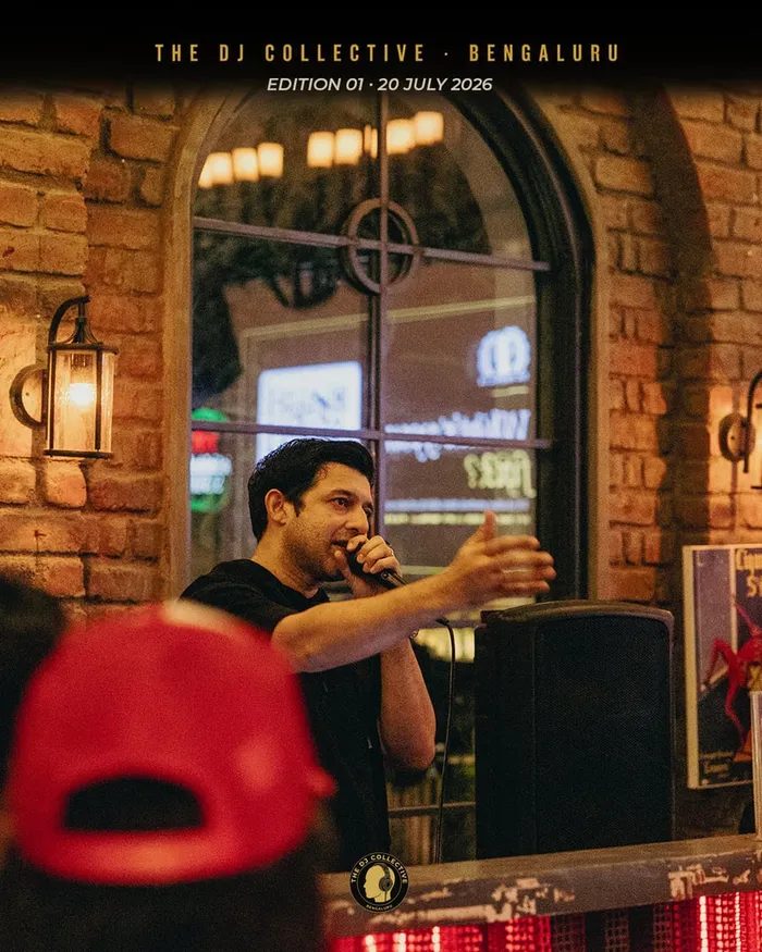 A DJ laughing near the bar, arm raised