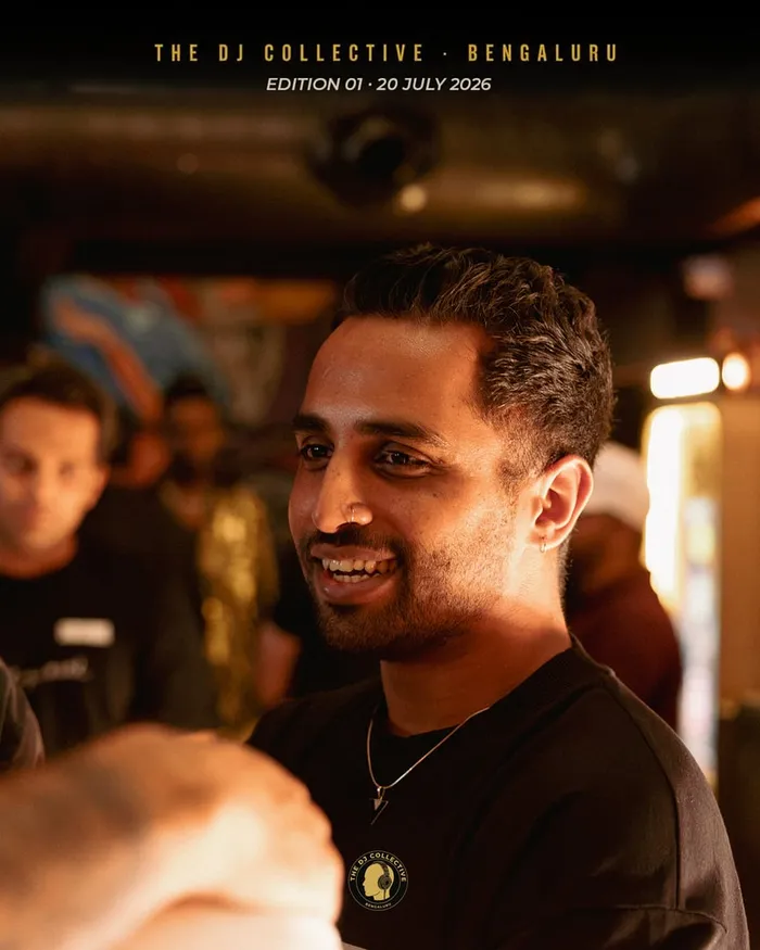 A DJ in black smiling in profile