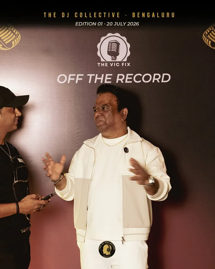 A DJ speaking to the room, hands mid-gesture