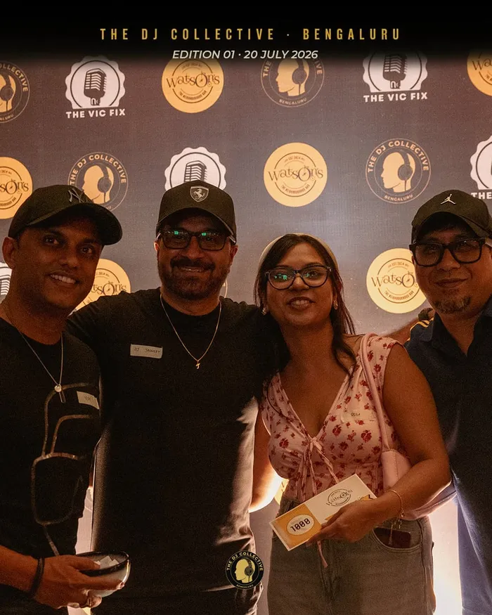 Four DJs posing together in front of the backdrop